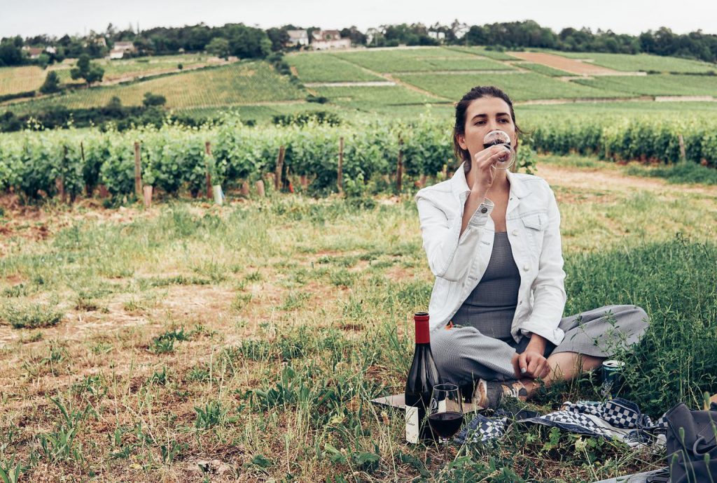 o que fazer em mendoza - mulher sentada na grama tomando vinho