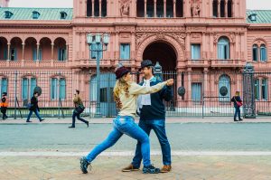 viagem para Argentina casal dançando tango em frente a casa rosada