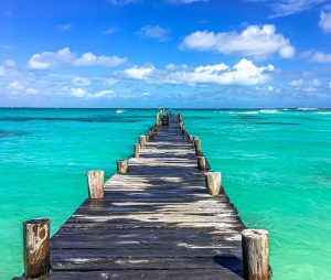 cancun ou maldivas - praia com água bem azul com o deck de madeira no meio