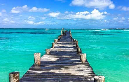 cancun ou maldivas - praia com água bem azul com o deck de madeira no meio